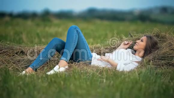 美丽的少女躺在金色的草草里视频的预览图