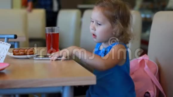 女孩在咖啡馆里吃快餐喝果汁视频的预览图