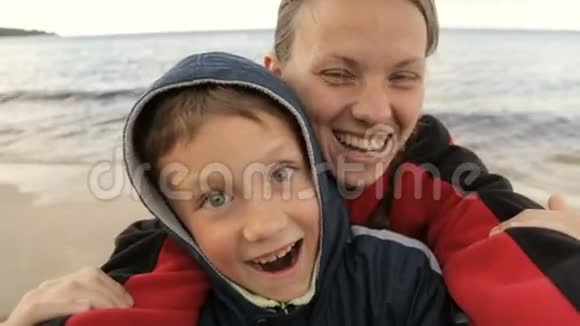 妈妈和孩子在大海的背景下给自己拍照视频的预览图