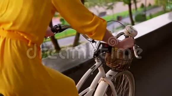 城市自行车的近景有铃铛篮子和鲜花的车把无法辨认的女人骑着城市自行车视频的预览图