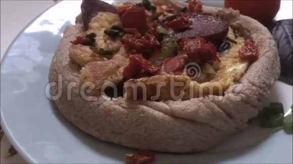 家做的披萨有意大利香肠和白色盘子上的蔬菜视频的预览图