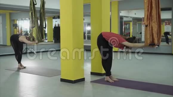 女性在空中瑜伽吊床的帮助下做一个名为Samakonasana的姿势视频的预览图