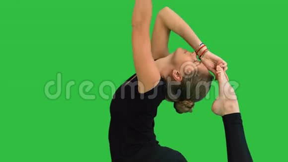 女人做伸展运动在绿色屏幕上练习瑜伽Chroma键视频的预览图