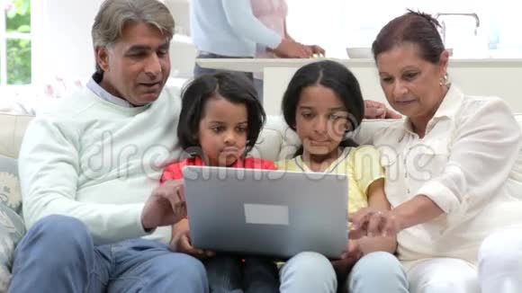 多代印度家庭笔记本电脑坐在沙发上视频的预览图