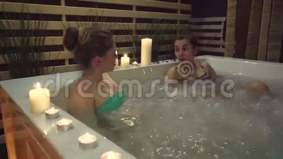 两个朋友在按摩浴缸里辛苦地休息了一天在温泉中心泡泡视频的预览图