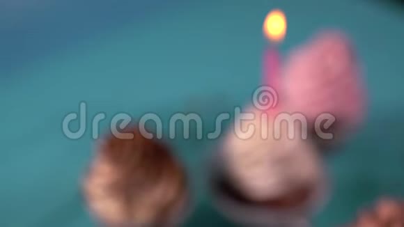 派对蜡烛放在粉红色的纸杯蛋糕上视频的预览图