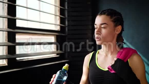 健身妇女带着毛巾在健身房休息锻炼和饮水瓶视频的预览图