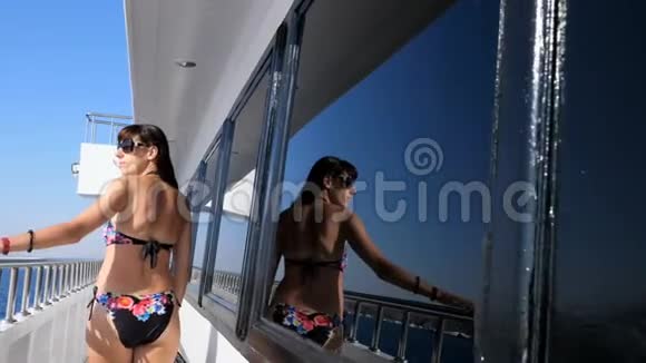 夏天大海美丽的年轻黑发女人穿着泳衣太阳镜沿着渡轮甲板船视频的预览图