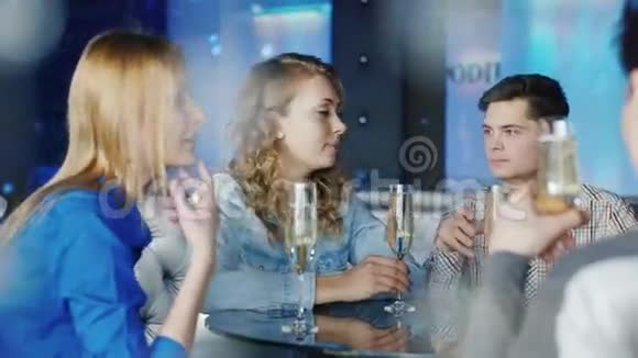 一群年轻的朋友在咖啡馆里放松好好玩吧老伴喝酒享受你的智能手机视频的预览图