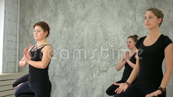 瑜伽练习一群妇女站在瑜伽馆的莲花位置视频的预览图