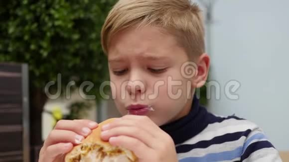 儿童在快餐店吃一个带鸡肉奶酪和蔬菜的面包视频的预览图