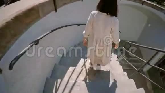 漂亮的黑发女人跑下楼梯视频的预览图