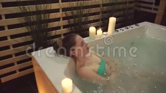 一位在按摩浴缸里的女士在一个安静的美容院氛围中享受水疗视频的预览图
