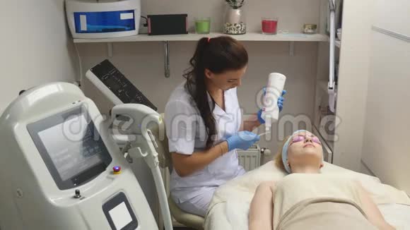美容师在手术前将凝胶涂在病人的脸上视频的预览图