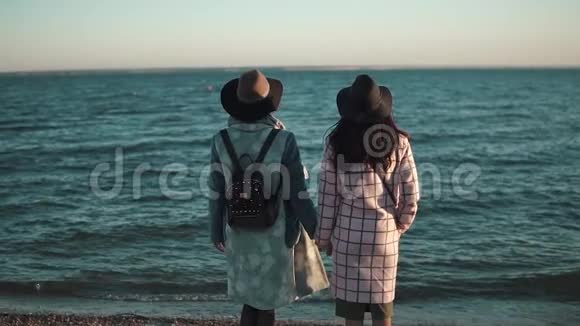 女朋友站在海边欣赏风景日落时穿秋衣的两个年轻女人从视频的预览图