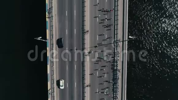 4的空中无人机飞行马拉松在桥上跑步垂直小车拍摄俯视视频的预览图