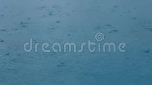 4K镜头无缝循环特写镜头雨水在水面上雨滴水坑无缝循环背景雨天天气视频的预览图
