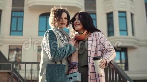 在现代建筑背景下两个穿着秋装的可爱年轻女人的肖像最好的朋友视频的预览图