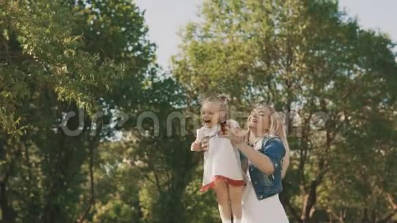 可爱的白种人母亲和她的小女儿在公园里玩得很开心视频的预览图