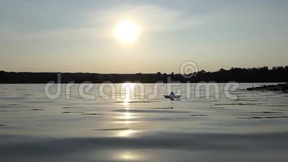 夕阳西下一只稚气的纸船在林湖中漂浮视频的预览图