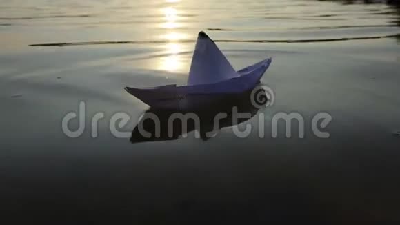 夕阳西下一艘白纸船在湖水中畅游视频的预览图