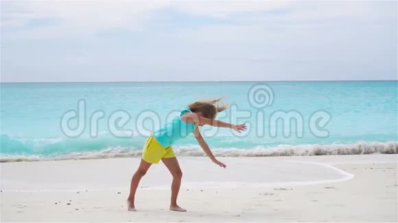活跃的小女孩在海滩上玩得很开心活泼的孩子在海边做轮子流动人口视频的预览图