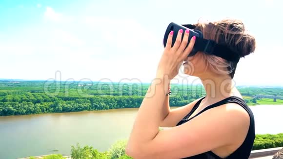 美丽的女人模拟在户外公园与VR虚拟现实耳机设备视频的预览图
