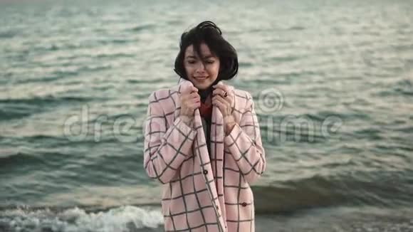 大海背景上一个穿秋装的可爱女孩的肖像视频的预览图