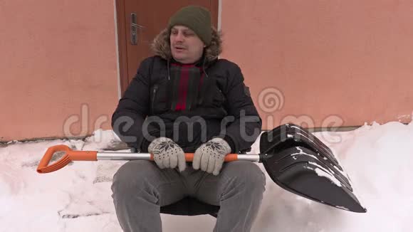 坐在轮椅上的残疾人用雪铲视频的预览图