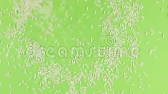 掉落的米粒在旋转的绿色屏幕上隔离视频的预览图