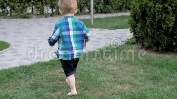 在公园的小径和草地上奔跑的可爱赤脚小男孩的慢动作视频视频的预览图