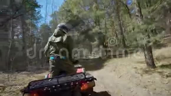 后景的ATV骑手操作他的越野车并通过森林滑翔从一边到另一边极端极端视频的预览图