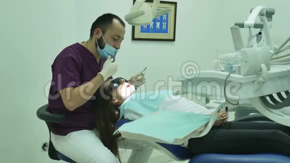 牙医检查一名妇女病人医疗诊所牙科设备视频的预览图