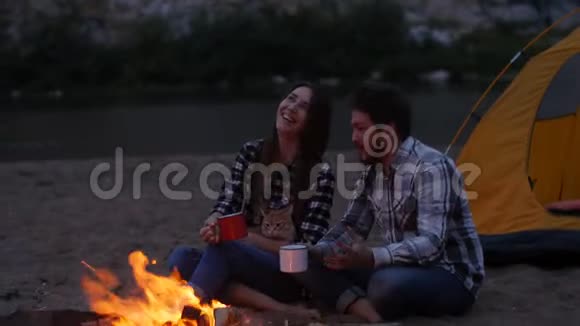 旅行和爱情的概念小可爱的一对在营地壁炉旁视频的预览图