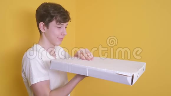 有披萨盒概念的快乐少年男孩打开一盒美味的披萨欢喜想吃披萨快速生活视频的预览图