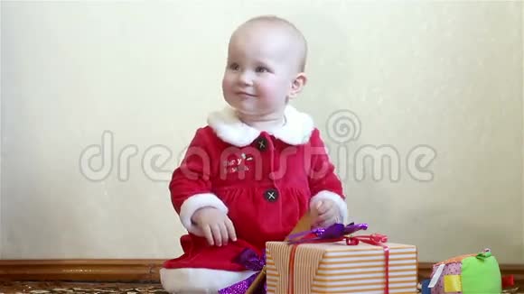 婴儿坐着鼓掌带礼物的derzhitkorobku视频的预览图
