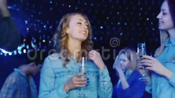 年轻女子拿着一杯香槟在迪斯科舞厅跳舞娱乐消遣和休闲视频的预览图