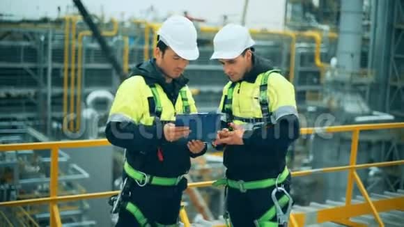 两名石油和天然气工人在炼油厂工作视频的预览图