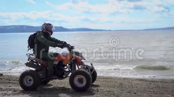 天气晴朗河岸穿着特殊制服和头盔的人骑在ATV河岸上视频的预览图