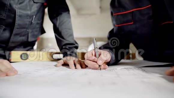 关闭男性手图设计方案和规范施工蓝图和水平躺在木桌上视频的预览图