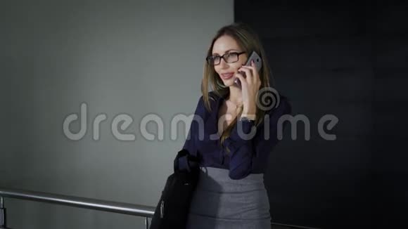办公楼的高级经理这个女人花了一段空闲时间打电话女孩在智能手机上说话视频的预览图