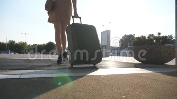 商务女士带着行李从机场去出租车停车场穿高跟鞋的女孩踩着行李箱视频的预览图