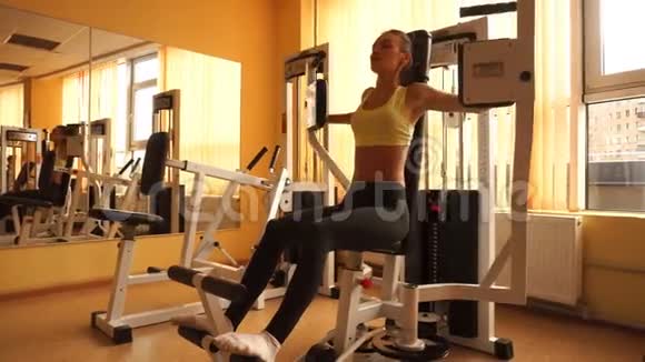 年轻漂亮的金发体育女孩在健身房练习4K视频的预览图
