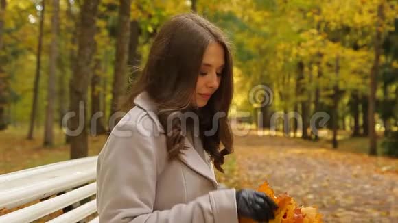 微笑的女人留着一束黄色的叶子向她的蜂蜜挥手视频的预览图