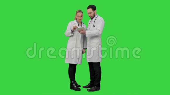 漂亮的女护士和英俊的医生用听诊器在绿色屏幕上使用数字平板电脑Chroma键视频的预览图