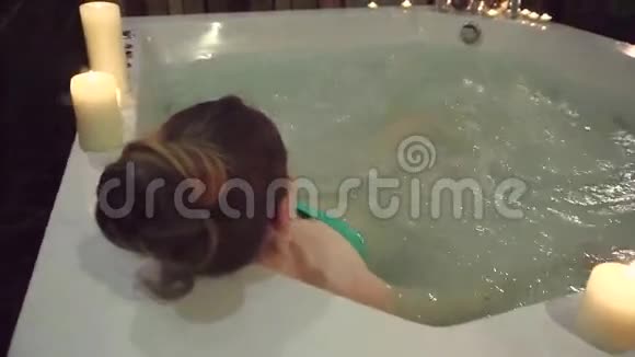 一个女人在水疗中心里拿着按摩浴缸享受芳香的蜡烛和安静视频的预览图