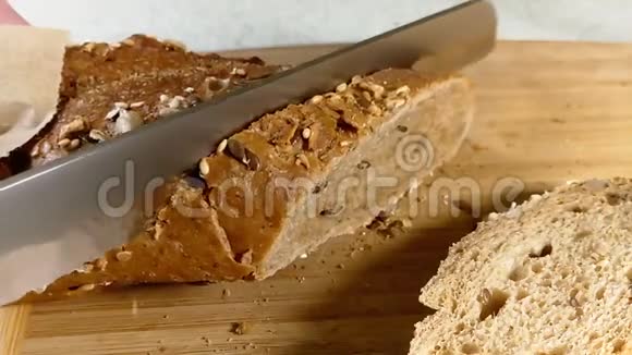 刀把谷物面包切在木头上视频的预览图