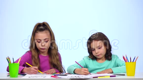幼儿姐妹用铅笔装饰图片白色背景慢动作视频的预览图