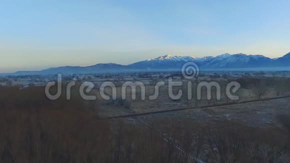 鸟瞰树林农场田野城市和远处雪山视频的预览图