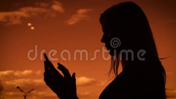 一个成年女孩逆天的剪影留着长发的女人在手机上打印一条信息它用一个小玩意视频的预览图